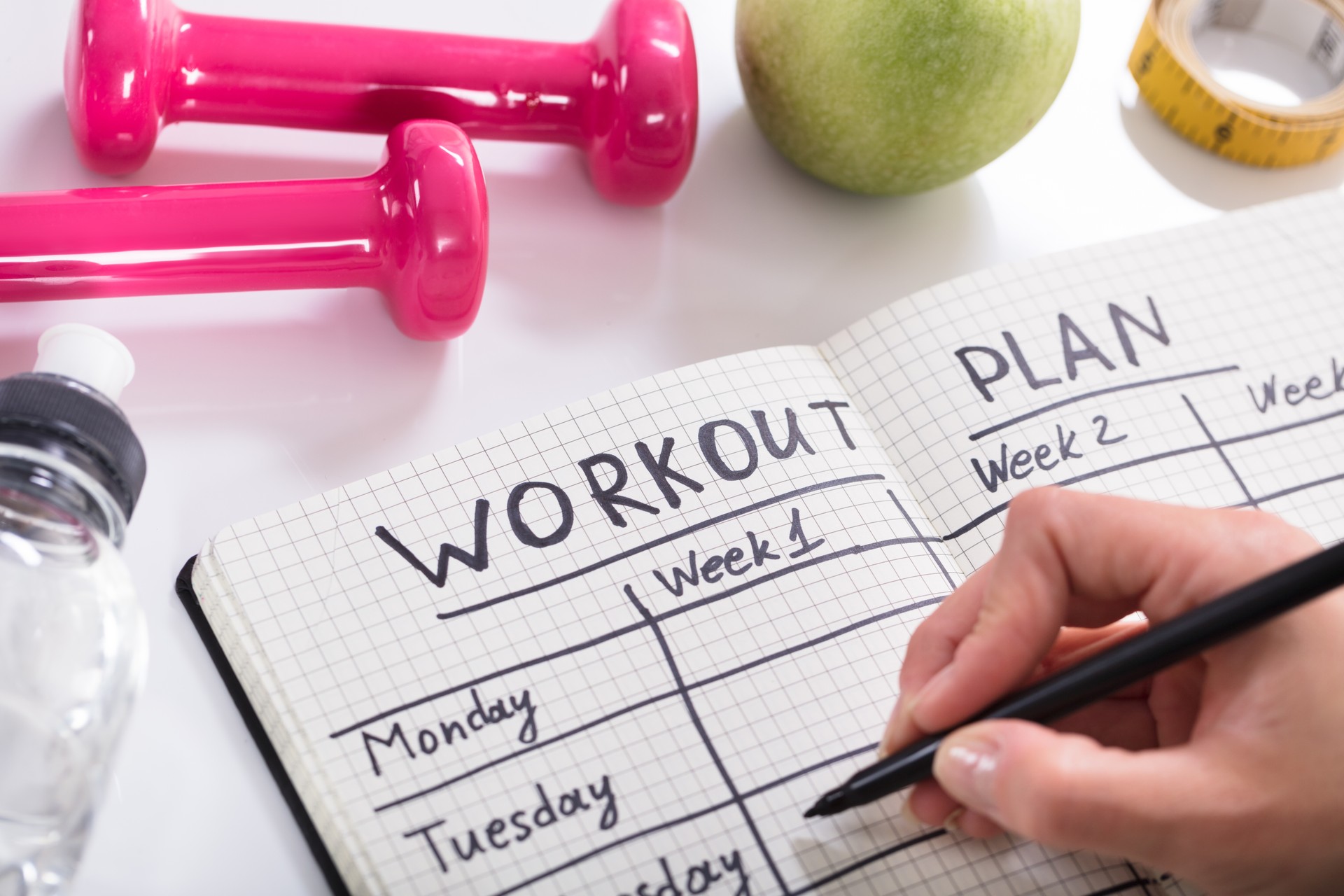 Workout Plan In Notebook At Wooden Desk